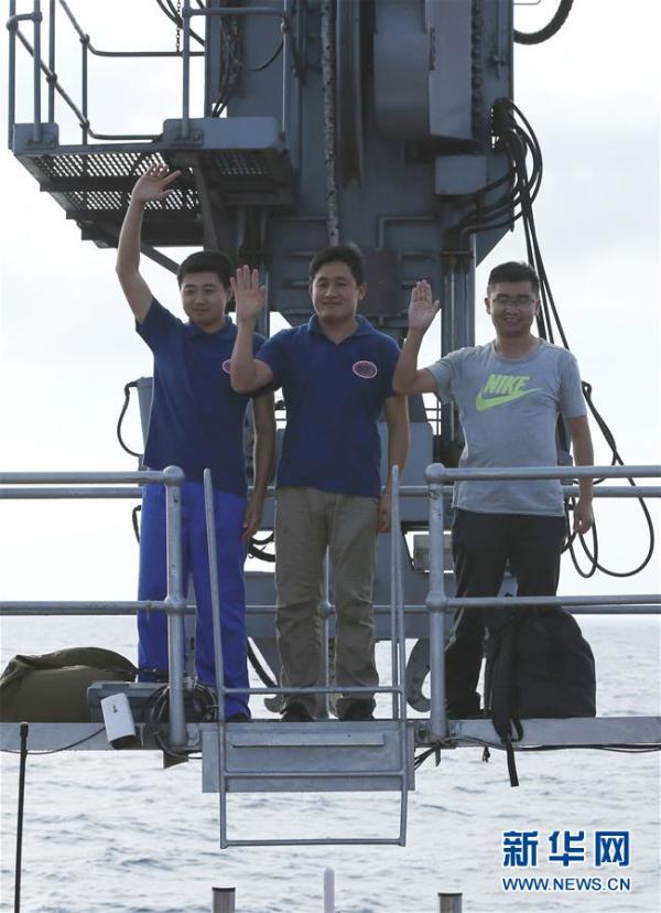 5月10日，科学家鹿博、主驾驶员齐海滨（中）和副驾驶员陈云赛（右）下潜归来。当日，“蛟龙”号载人潜水器首次迎来两位实习潜航员担任主、副驾驶下潜作业，这也是中国大洋38航次第二航段在南海的最后一潜。本潜次作业任务以近底测线观察为重点，补充调查为目的，对浦元海山的多金属结核和巨型底栖生物分布情况进行了进一步探寻，完成了环境参数测量和土木力学原位测试，采集了近底海水、沉积物、结核和生物样品。新华社记者 刘诗平 摄
