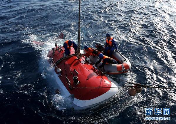 5月10日，“蛙人”系缆，“蛟龙”号完成下潜准备回到船上甲板。当日，“蛟龙”号载人潜水器首次迎来两位实习潜航员担任主、副驾驶下潜作业，这也是中国大洋38航次第二航段在南海的最后一潜。本潜次作业任务以近底测线观察为重点，补充调查为目的，对浦元海山的多金属结核和巨型底栖生物分布情况进行了进一步探寻，完成了环境参数测量和土木力学原位测试，采集了近底海水、沉积物、结核和生物样品。新华社记者 刘诗平 摄