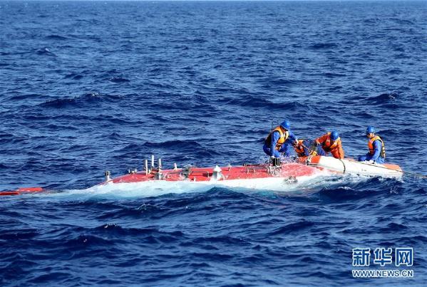 5月10日，“蛙人”系缆，“蛟龙”号完成下潜准备回到“向阳红09”科学考察船上。当日，“蛟龙”号载人潜水器首次迎来两位实习潜航员担任主、副驾驶下潜作业，这也是中国大洋38航次第二航段在南海的最后一潜。本潜次作业任务以近底测线观察为重点，补充调查为目的，对浦元海山的多金属结核和巨型底栖生物分布情况进行了进一步探寻，完成了环境参数测量和土木力学原位测试，采集了近底海水、沉积物、结核和生物样品。新华社记者 刘诗平 摄